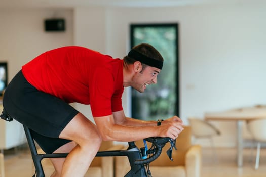 A triathlete riding a triathlon bike on a machine simulation in a modern living room.