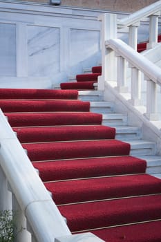 Steps adorned with red carpet lead to an inviting upper level.