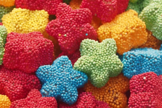 Brightly colored star-shaped candies in various hues create a cheerful display.