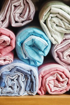Neatly stacked rolled towels in various colors enhance the bathroom decor.