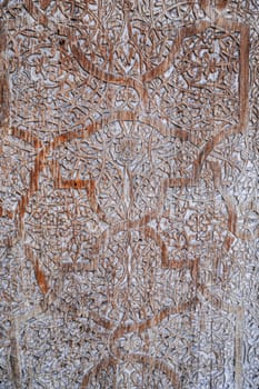 traditional Uzbek retro carved pattern kandakori on vintage old wooden door in Tashkent in Uzbekistan close-up