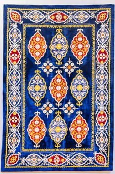 traditional Uzbek geometric pattern on an ancient handmade carpet in Uzbekistan. Oriental background with beautiful ornaments on white isolated background