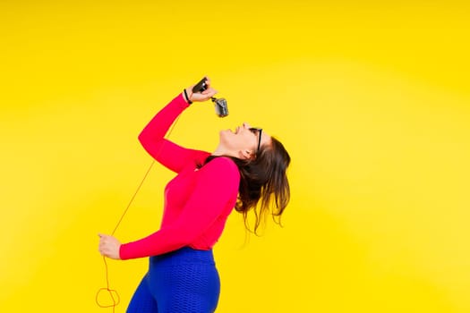 Smiling brunette woman with microphone on a colored studio background
