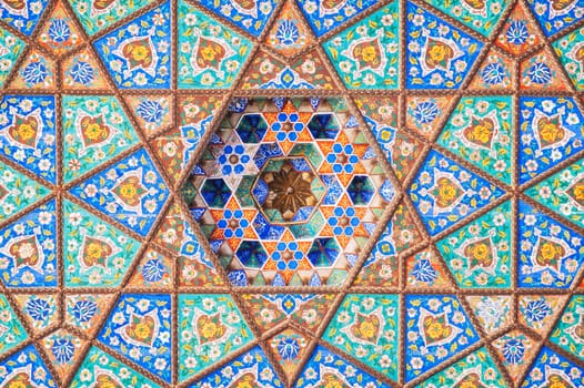 beautiful carved wooden painted background of ceiling in Museum of Art of Uzbekistan with traditional Uzbek ornaments and colorful oriental patterns in Tashkent