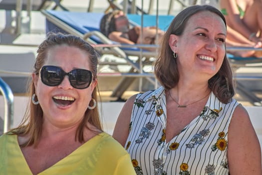 Portrait of two women wearing contemporary, vibrant fashion. Both pose gracefully outdoors, complemented by soft lighting and a peaceful atmosphere.