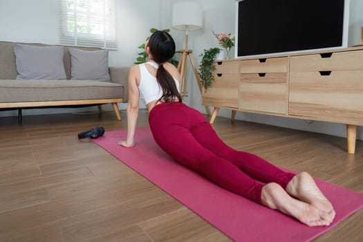 Demonstrating strength and grace, the woman executes the upward-facing cobra pose, showcasing her commitment to yoga.