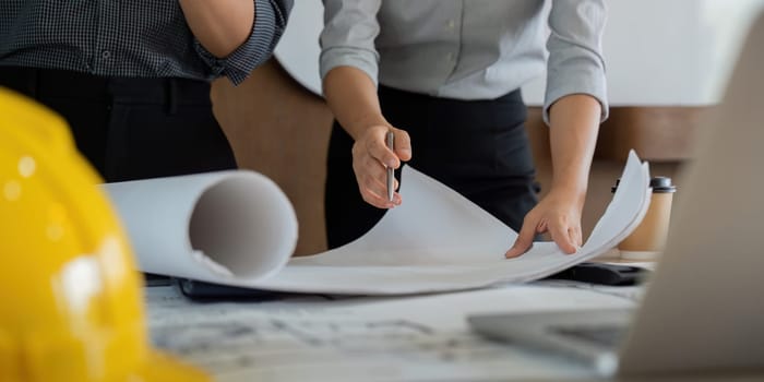 Detailed focus on engineers as they analyze and discuss essential project drawings and notes, underscoring the importance of thorough preparation in engineering endeavors.