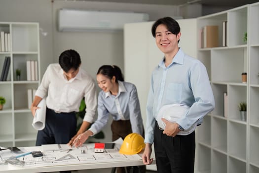 In a bright office, a team works together, reviewing project diagrams, showcasing their commitment and teamwork in a structured environment.