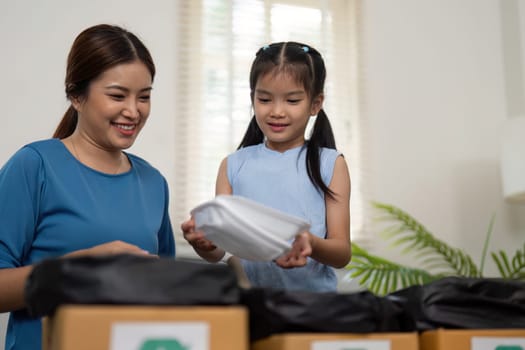 A mother and daughter joyfully engage in recycling activities, emphasizing the importance of eco-consciousness and practical skills in daily life.