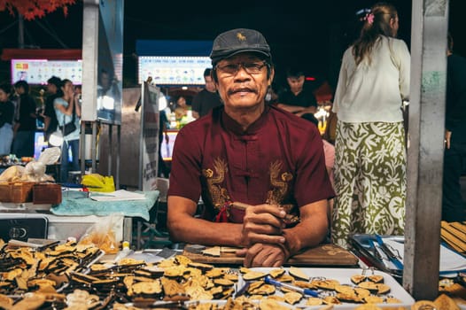 Asian man craftsman Vietnamese artisan at a souvenir shop at a market in Da Nang in Asia. Da Nang, Vietnam - November 29, 2024