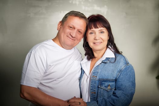 Middle-aged couple joyfully posing together inside their apartment, showcasing love and affection during a family photoshoot.