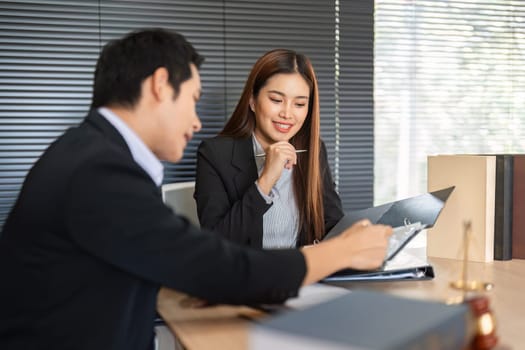 A female client assesses important legal documents while consulting with her lawyer, indicating the collaborative nature of their partnership in navigating legal issues.