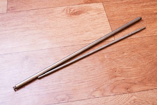 A beautifully crafted pair of chopsticks gently laying on a polished wooden surface, showcasing the natural material and craftsmanship
