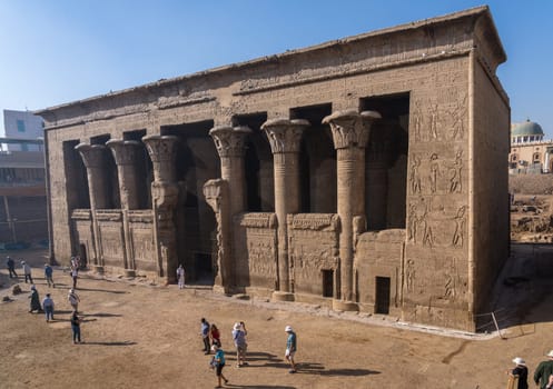 Esna, Egypt - 3 November 2024: Tourists admire the well-preserved facade of the Temple of Esna, a Greco-Roman temple in Egypt.