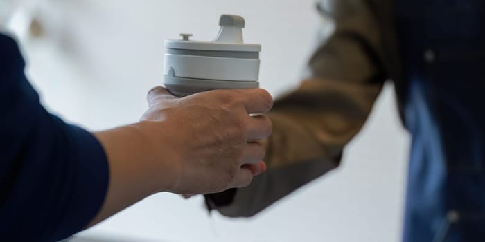 A customer receives a reusable cup from a barista, highlighting eco-conscious choices in daily life and the importance of sustainability.