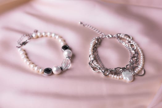 Jewelry on satin fabric with pearl bracelets and wheat elements. Handmade bijouterie And natural aesthetics in fashion.
