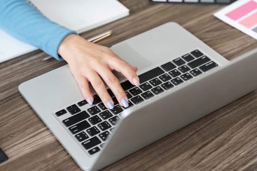 A close-up of hands typing on a laptop keyboard, emphasizing productivity and creativity in the workplace.