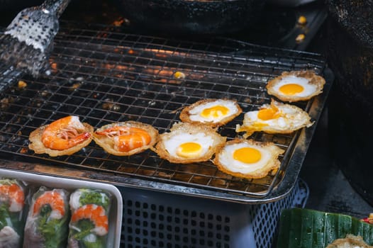 cooked traditional Vietnamese dish Banh Khot with shrimps and corn at Asian night market on street in Vietnam in Asia
