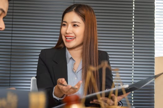 A female client smiles while interacting with her lawyer, signifying a positive client-lawyer relationship during their strategic discussion over legal matters.