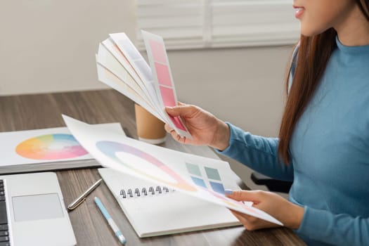 In a modern office, a designer explores different color swatches, blending creativity with practicality to finalize design choices.