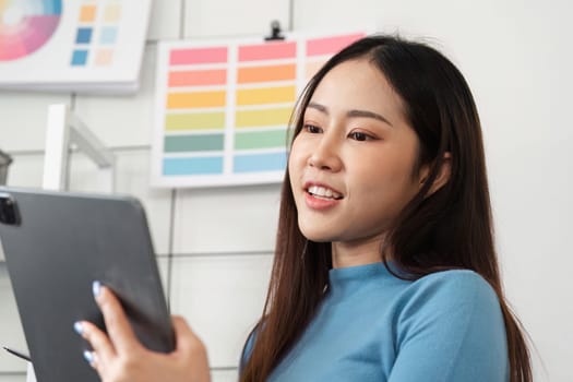 A designer captivates herself with a tablet while making informed decisions about her color options for a significant design project.