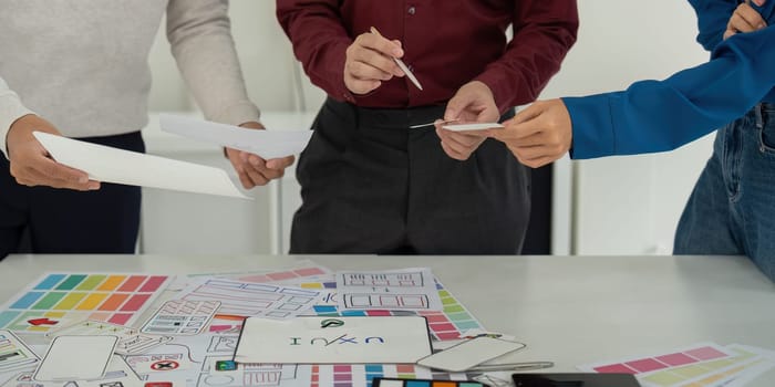A UX team assessing design ideas and usability features, with a focus on creative problem-solving and collaboration to finalize their proposals.