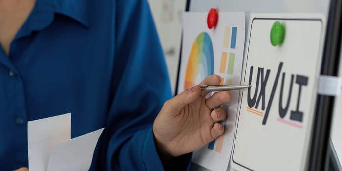 Collaborators work together on a UX UI design project, discussing layouts and visual elements. The creative environment fosters innovation and teamwork in digital product development.