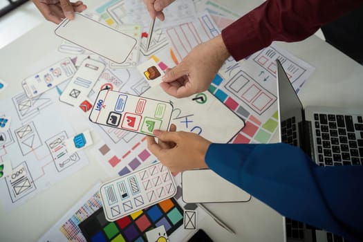 Designers engage in a vibrant session, exchanging ideas and layouts while analyzing feedback. This interaction shapes the direction of their UI design project.
