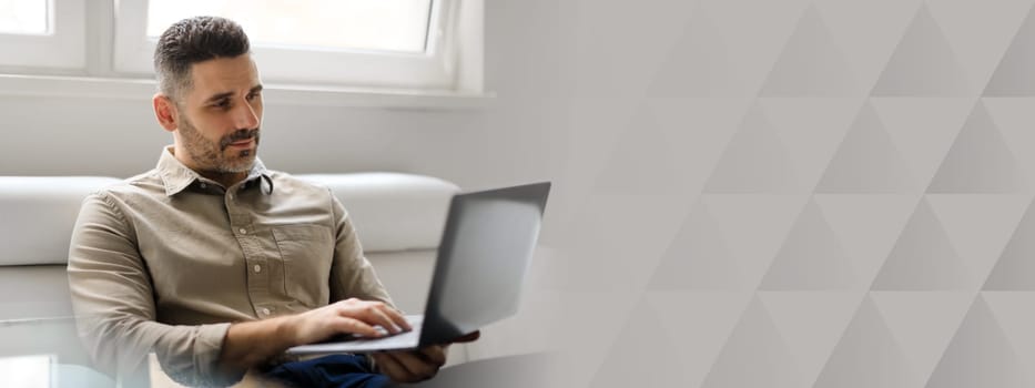 A middle aged businessman is focused on his laptop while seated in a well-lit corporate office. He appears engaged in work, reflecting a lifestyle of success and entrepreneurship, copy space