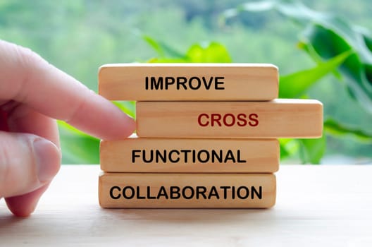 Improve Cross Functional Collaboration text on wooden blocks representing continuous improvement in business strategy.