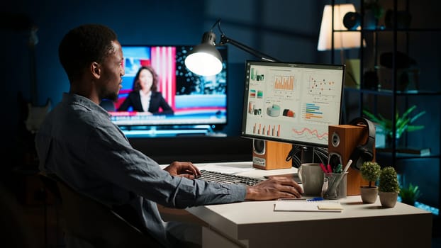 Network analyst studying digital commerce progression reports on computer, working at home to boost earnings and gain shareholder backing. Specialist analyzes company information. Camera A.
