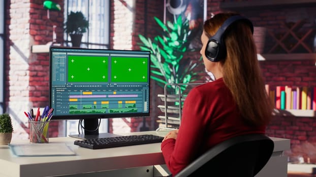 Female video creator working on editing a movie with green screen, using a movie post production software. Female footage editor starting the cinematic film editing industry. Camera A.