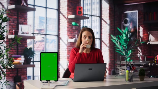 Person uses laptop for creative projects next to isolated copy space, creating designs while staying connected to the freelance platform. Woman focusing on research and multitasking. Camera B.