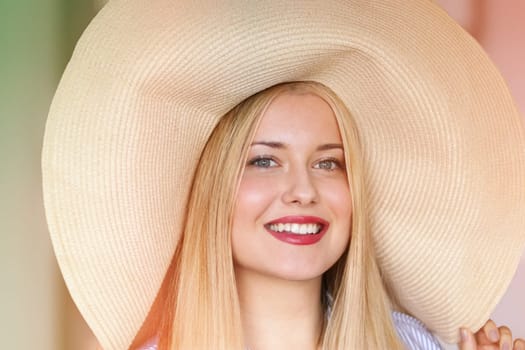 Woman, fashion and summer country charm, blonde beauty and elegance in wide brimmed beach hat. Feminine allure, timeless style and graceful glow. Smile, straw hat and blue striped blouse, natural lighting and effortless charm, fashion look idea