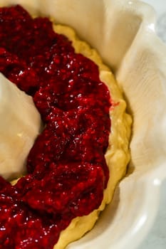 After greasing the bundt cake pan, it's time to fill it with the prepared cake batter and delightful raspberry cake filling - creating a perfect harmony of flavors.