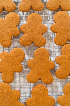 Close-up of golden-brown gingerbread men with heart-shaped cutouts cooling on a wire rack.
