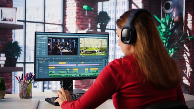 Female filmmaker working on media post production from agency office, ensuring the editing timeline and color correction for video shoot. Tech driven workspace showcases workflow. Camera B.