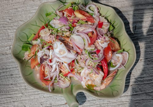 Top view of Spicy seafood salad with Lemongrass (Thai style spicy) on Ceramic plate. use it as your Wallpaper, Poster and Copy space, Selective focus.