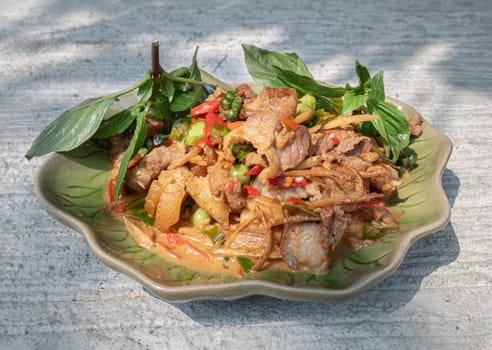 Stir-fried spicy Wild boar with Herbs and Fresh green peppercorns on Ceramic plate. use it as your Wallpaper, Poster and Space for text, Selective focus.