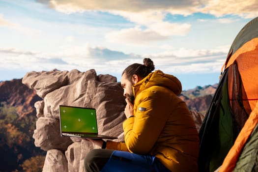 Active hiker gazes at the panoramic sky and copy space display, feeling the sense of peace that comes with exploring the great outdoors. Breathtaking landscape symbolizes resilience.