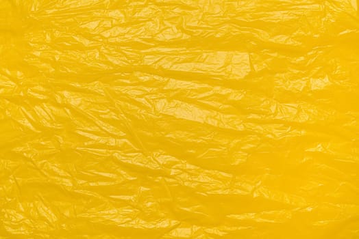 A textured yellow crumpled paper background with natural creases and folds. Ideal for design projects, digital graphics, or creative presentations requiring a vibrant.
