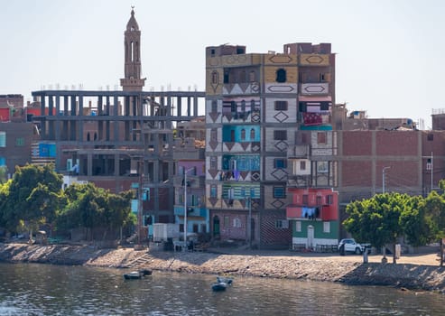 Esna, Egypt - 3 November 2024: Colorful newly constructed homes by the banks of the Nile in Esna