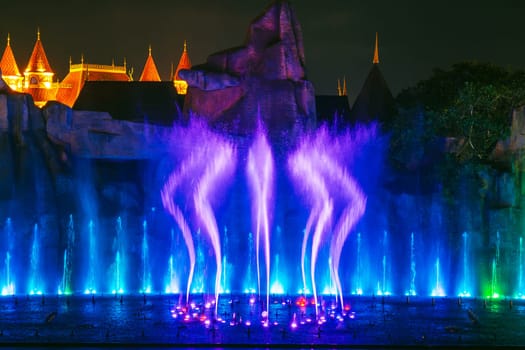 beautiful bright blue illuminated dancing and singing fountain at night. Musical performance show