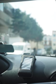 A pos machine rests on a car dashboard