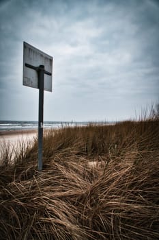 View over the dunes on the island of Usedom to the Baltic Sea. Dune grass, bathing sign and white sand. Nature photo from the coast