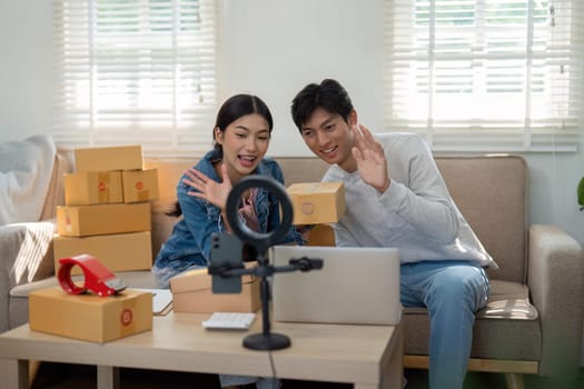 A young woman and man actively engaging with their online audience as they present products from their latest shipment, fostering excitement and connection.