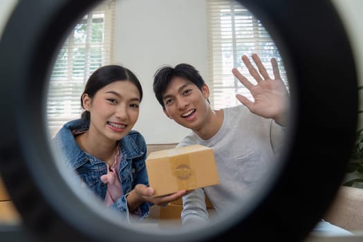 In a candid shot, the couple poses with a product box, highlighting their enthusiasm and readiness for an online presentation, embodying the spirit of marketing and promotion.