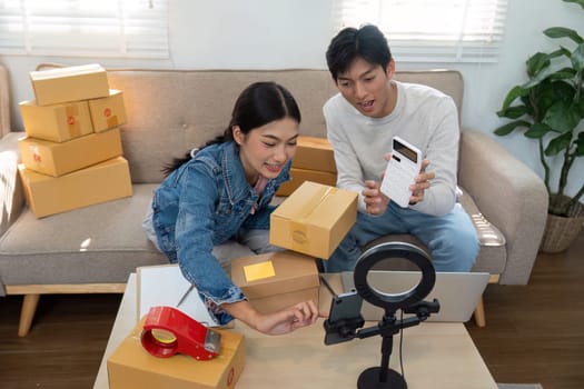 Two entrepreneurs are efficiently managing their e-commerce orders, showcasing teamwork as they package items and prepare for delivery at home.