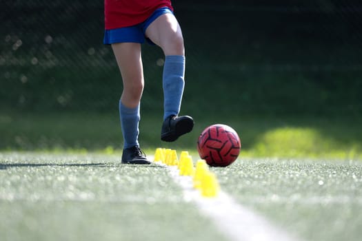 Girl Skillfully Dribbles Ball Between Flip Cups During Football Practice, Close-Up Shot