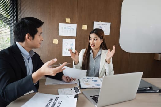 A female professional expresses her ideas animatedly while her male counterpart listens attentively, showcasing effective communication in the workplace.